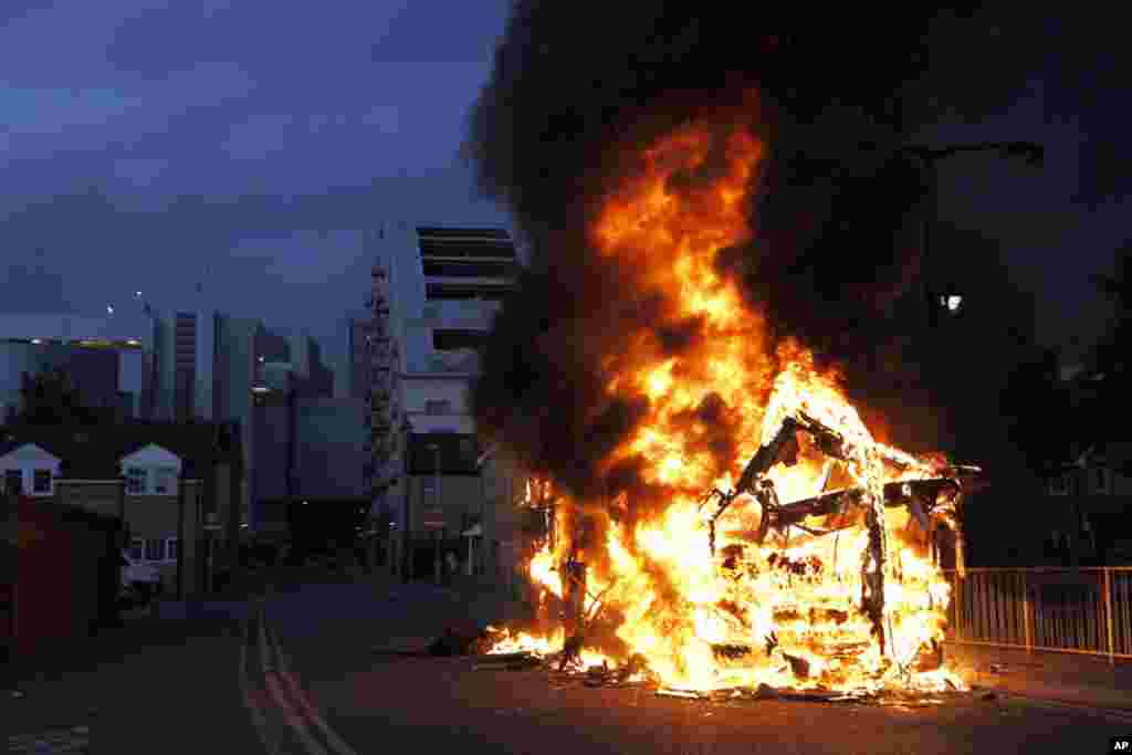 A bus is set on fire as rioters gathered in Croydon, south London, Monday, Aug. 8, 2011. Violence and looting spread across some of London's most impoverished neighborhoods on Monday, with youths setting fire to shops and vehicles, during a third day of r