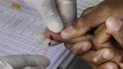 A patient undergoes a pin prick blood test inside a mobile healthcare clinic parked in downtown Johannesburg, 29 Nov 2010