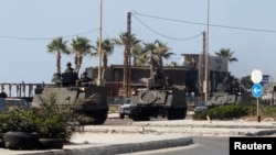 Lebanese Army soldiers on armored vehicles move towards an area of clashes in Sidon, southern Lebanon, June 23, 2013. 