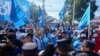 Partidarios del presidente Nayib Bukele, que busca la reelección, se reúnen frente al colegio electoral donde votó, en San Salvador, El Salvador, el domingo 4 de febrero de 2024. (Foto AP/Moises Castillo)