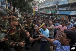 Bangladesh Hindus, participating in a rally to demand that an interim government withdraw all cases against their leaders and protect them from attacks, argue with security personnel in Chattogram, Bangladesh, Nov. 1, 2024.