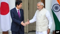 日本首相安倍和印度总理莫迪在新德里握手（2015年12月12日）