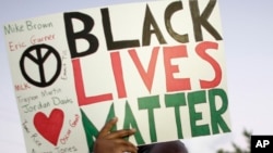 FILE - А protester holds up a sign reading "Black Lives Matter," with the names of black men killed by police, during a rally, in Miami, Florida, Dec. 5, 2014. Albright College students in Pennsylvania have been criticized for lampooning the movement in a video.