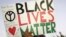 FILE - А protester holds up a sign reading "Black Lives Matter," with the names of black men killed by police, during a rally, in Miami, Florida, Dec. 5, 2014. Albright College students in Pennsylvania have been criticized for lampooning the movement in a video.