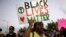 Desiree Griffiths holds up a sign saying "Black Lives Matter", with the names of Michael Brown and Eric Garner, two black men recently killed by police, during a protest , in Miami, Florida, Dec. 5, 2014. 