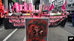 Women activists display a sign in solidarity with protests in Myanmar as they march near the Malacanang presidential palace to mark International Women's Day on Monday March 8, 2021, in Manila, Philippines. 