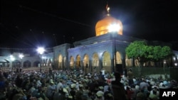 FILE - Syrian Shiites pray outside the shrine of Sayyida Zeinab in Damascus, June 28, 2016. Syria's de facto government said on Jan. 11, 2025, that it had averted a plan by the Islamic State to bomb the shrine.