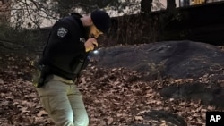 A New York City Police officer searches for evidence related to the killing UnitedHealthcare CEO Brian Thompson, in Central Park in New York, Dec. 6, 2024.