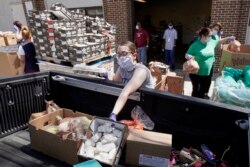 FILE - Workers at a food pantry called Together Omaha load supplies into a vehicle in Omaha, Nebraska, April 23, 2020, to assist Americans affected by the coronavirus pandemic.