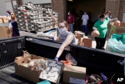 FILE - Workers at a food pantry called Together Omaha load supplies into a vehicle in Omaha, Nebraska, April 23, 2020, to assist Americans affected by the coronavirus pandemic.