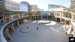 A woman walk through an empty plaza at City Creek Center in Salt Lake City, Utah, where several major malls have announced their reopening from May 6, 2020. 