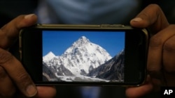 A photo of K2, the world's second-highest mountain, is displayed on a cell phone in Islamabad, Pakistan, Feb. 9, 2021. 