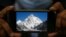 A photo of K2, the world's second-highest mountain, is displayed on a cell phone in Islamabad, Pakistan, Feb. 9, 2021. 