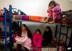 Mexican migrant Carmen Aros and four of her five daughters wait for news before attempting to cross the border into the U.S while staying at a church-run shelter in Ciudad Juarez, Mexico, Dec. 18, 2022.