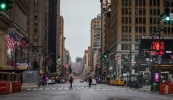 A usually busy 7th Avenue is mostly empty of vehicles, the result of citywide restrictions calling for people to stay indoors and maintain social distancing in an effort to curb the spread of COVID-19, March 28, 2020, in New York.