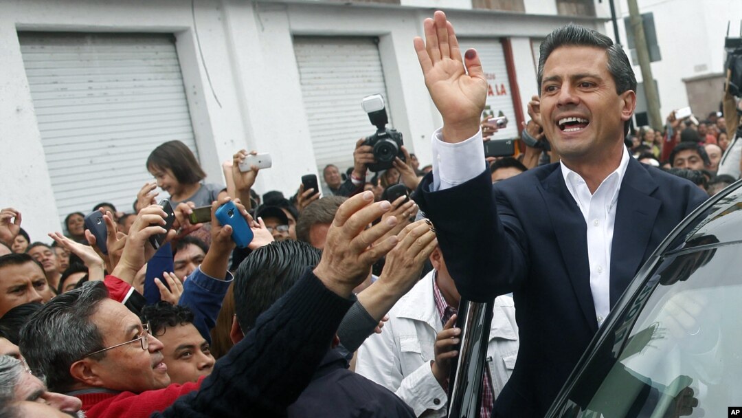 Enrique Pena Nieto (kanan), yang diperkirakan akan memenangkan pilpres Meksiko, melambai kepada para pendukungnya, Minggu (1/7).