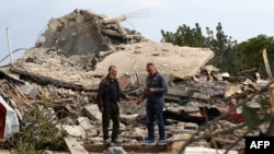 Men check the site of an Israeli air strike in the southern Lebanese village of Jibshit on Feb. 27, 2024.