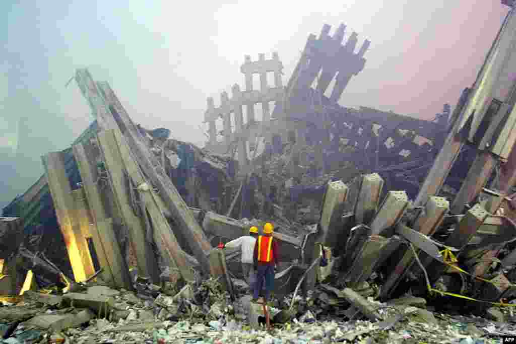 (FILE)Rescue workers survey damage to the World Trade Center 11 September, 2001 in New York. Two planes controlled by hijackers crashed into the twin towers of the center destroying the buildings. At almost the same time, another hijacked plane flew into the Pentagon in Washington, DC. AFP PHOTO Doug KANTER (Photo by DOUG KANTER / AFP)