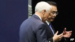 El vicepresidente EE.UU., Mike Pence, conversa con el primer ministro chino, Li Keqiang, en Singapur el 15 de noviembre de 2018.