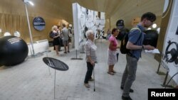 Visitors read information about corruption inside a giant tent, at the "Corruption Park" in Kyiv, Ukraine, June 14, 2018.