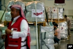 Pegawai Bulan Sabit Merah Qatar menyiapkan paket bantuan yang akan dikirim untuk para korban di wilayah yang dilanda gempa di Turki, di Pangkalan Udara Al-Udeid, Doha, Qatar, Selasa, 7 Februari 2023. (AP/Kamran Jebreili)