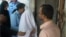 Rimsha Masih, covered by a white sheet, is escorted by police from a court in Islamabad, Pakistan on Aug. 31, 2012.