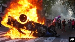 A protester burns a police car during a demonstration by soccer fans and retirees demanding higher pensions and opposing austerity measures implemented by Javier Milei's government in Buenos Aires, Argentina, March 12, 2025. 