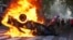 A protester burns a police car during a demonstration by soccer fans and retirees demanding higher pensions and opposing austerity measures implemented by Javier Milei's government in Buenos Aires, Argentina, March 12, 2025.