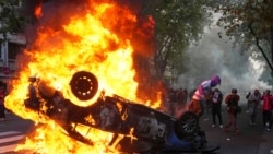 Seorang demonstran membakar mobil polisi dalam aksi protes yang diikuti penggemar sepak bola dan pensiunan yang meminta pensiun lebih tinggi di Buenos Aires, Argentina, pada 12 Maret 2025. (Foto: AP/Rodrigo Abd)