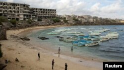 FILE - People stand and walk on a beach in the old port of Mogadishu, Somalia, Nov. 13, 2013. Global watchdog Transparency International said its latest annual Corruption Perceptions Index report showed pervasive public-sector corruption around the world. Somalia remained the worst performer with a score of 10, followed by South Sudan, with a score of 11.