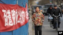 A woman walks outside the housing compound of jailed Chinese dissident Liu Xiaobo, the 2010 Nobel Peace Prize winner, in Beijing, Dec. 8, 2010. Liu is to be honored on Dec. 10 at the Nobel awards ceremony in Oslo.