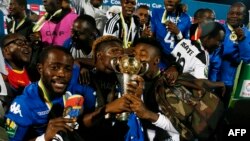 Les joueurs de TP Mazembe célèbrent avec le trophée leur victoire sur Supersport United au terme de la finale retour de la Coupe de la CAF, au stade Lucas Moripe, à Atteridgeville, Pretoria, 25 novembre 2017. AFP PHOTO / PHILL MAGAKOE