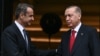 Presiden Turki Recep Tayyip Erdogan (kiri) berjabat tangan dengan Perdana Menteri Yunani Kyriakos Mitsotakis saat melakukan kunjungan resmi ke Yunani, di Athena, pada 7 Desember 2023. (Foto: AFP)