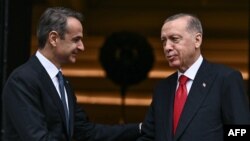 Presiden Turki Recep Tayyip Erdogan (kiri) berjabat tangan dengan Perdana Menteri Yunani Kyriakos Mitsotakis saat melakukan kunjungan resmi ke Yunani, di Athena, pada 7 Desember 2023. (Foto: AFP)