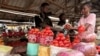 Farouk Dalhatu, um vendedor de tomates, atende um comprador num mercado comunitário de Agodo, em Lagos. FOTO DE ARQUIVO