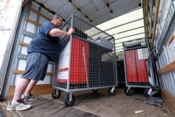 Patrick Lathem loads a truck containing packed polling place equipment after dismantling a polling place in Wintersville, Ohio, March 17, 2020. Ohio's presidential primary was postponed amid coronavirus concerns.