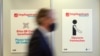 A person walks past pictograms in the vaccination center at the football stadium in Duesseldorf, western Germany, Dec. 1, 2020. Preparations are under way to install a vaccine facility amid the novel coronavirus pandemic. 