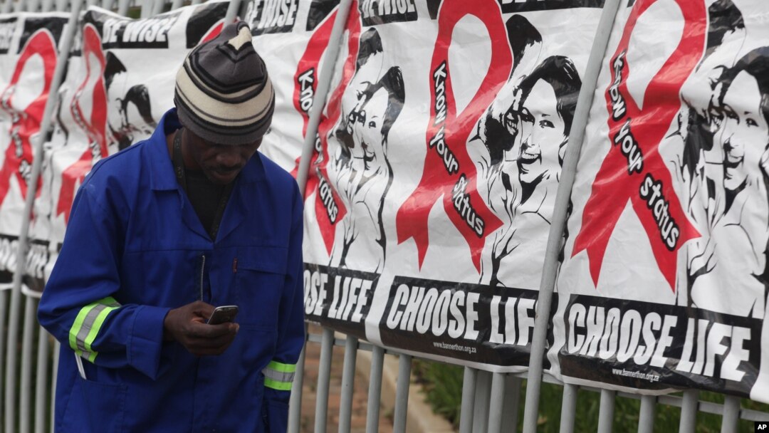 Seorang pria melewati poster Hari AIDS Sedunia di gedung perkantoran di Sandton, Johannesburg, Afrika Selatan, 1 Desember 2014. 