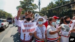 Demonstrators in ethnic Chin attire flash a three-fingered symbol of resistance during a protest against the recent military coup in Yangon, Myanmar Thursday, Feb. 11, 2021.