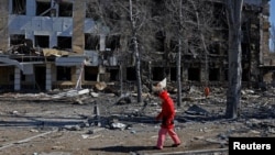 在俄乌军事冲突期间，一名女子走过一家位于乌克兰境内由俄罗斯控制的顿涅茨克的儿童医院。该院所在建筑物遭炮击受损，当时该医院正处于维护期，内部并无病患。(2026年3月9日)