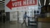 A worker walks past a voting sign inside the Martin Luther King library that will be used as a polling place on election day in Washington, DC, on November 4, 2024.