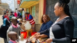 FILE — Njeri Migwi, a woman human rights defender and the Co-Founder of Usikimye, serves lunch to children from her school feeding program in downtown Nairobi, Kenya, March 4 2024.