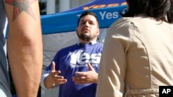 Marcus Ruiz Evans, centro, activista por la propuesta The Yes California Independence Campaign, trata de conseguir firmas de apoyo para la independencia de California.