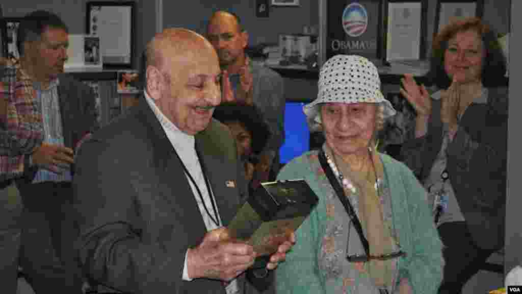 Leo Sarkisian, with his wife Mary looking on, enjoys a gift presented to him by colleagues at his retirement party.