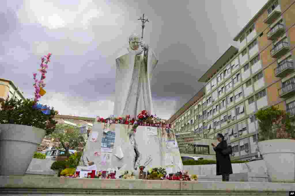 People pray for Pope Francis in front of the Agostino Gemelli Polyclinic, in Rome, Italy, where the Pontiff is hospitalized since Feb. 14.