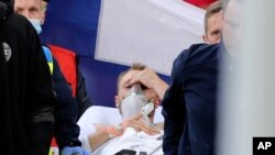 Paramedics using a stretcher to take out of the pitch Denmark's Christian Eriksen after he collapsed during the Euro 2020 soccer championship group B match between Denmark and Finland at Parken stadium in Copenhagen, Denmark, June 12, 2021.