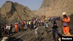 Warga setempat berkumpul dekat lokasi terjadinya lumpur longsor di pertambangan giok Hpakant, negara bagian Kachin, Myanmar, Kamis (23/4). 