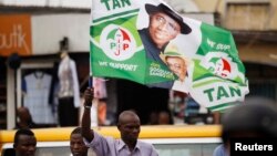 A man holds a flag in support of Nigerian President Goodluck Jonathan at a campaign rally for Lagos governorship candidate Jimi Agbaje of the People's Democratic Party in Lagos, Feb. 3, 2015.