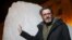 Olafur Eliasson, a Danish-Icelandic artist, poses in front of a block of ice that was havested in Greenland and transported in a refrigerated container for a project called "Ice Watch," in Paris, France, Dec. 3, 2015