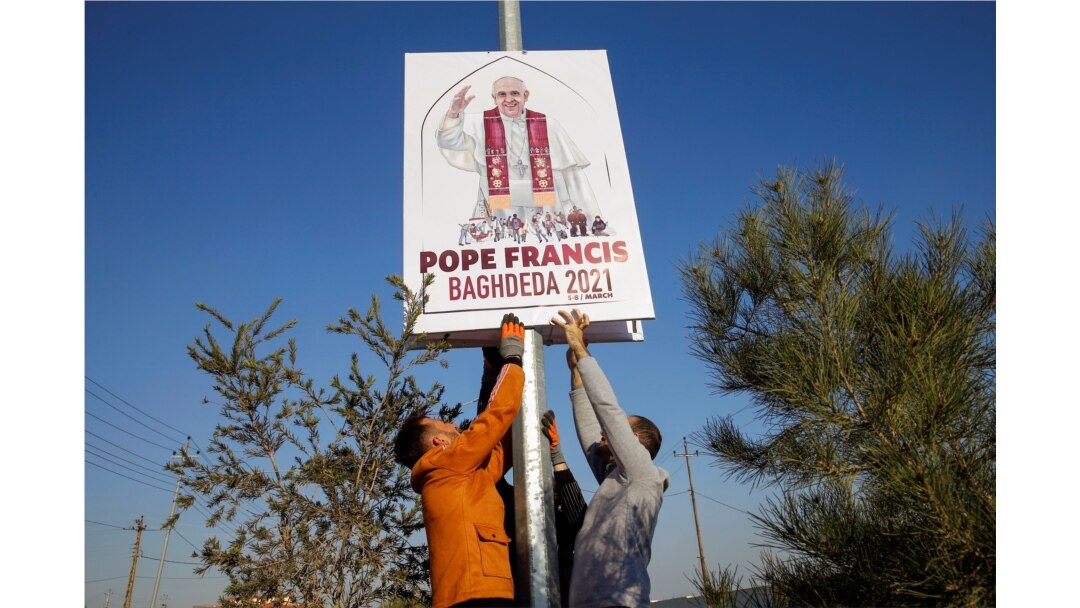Christians volunteers decorate streets with the pictures of Pope Francis, ahead of his planned visit to to Iraq, in Qaraqosh, Iraq, Feb. 22, 2021.